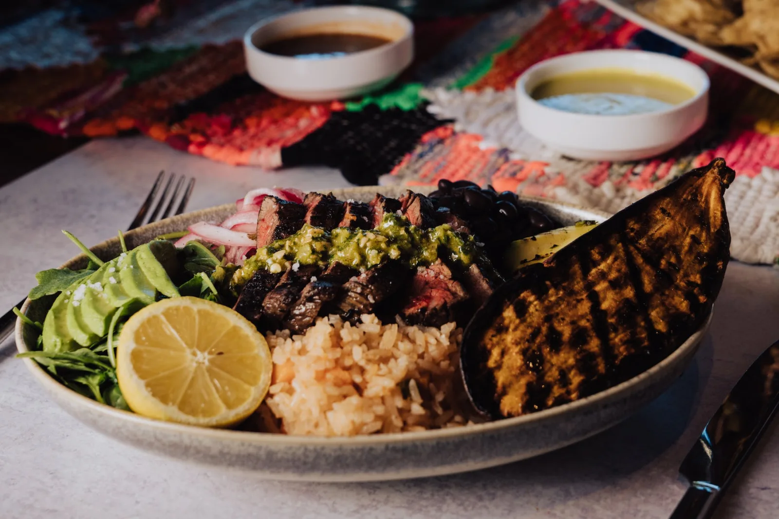 Sliced steak, rice, beans, avocado and vegetables at LUNA